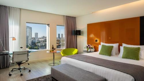 una camera d'albergo con letto, scrivania e finestra di Crowne Plaza Tel Aviv City Center, an IHG Hotel a Tel Aviv