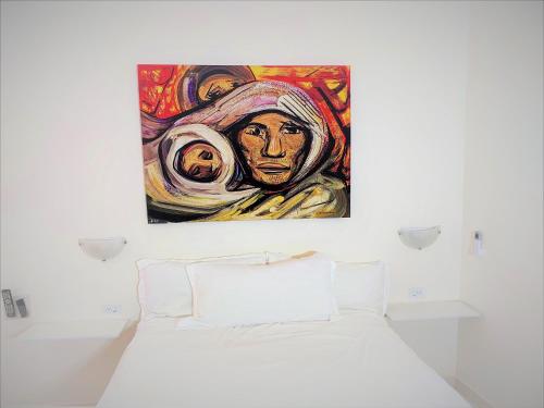 una pintura de una mujer en una pared sobre una cama en Loft 25 excelente y comodo, cerca del vado del rio, consulado,CAS, galerias mall , cama queen , cocineta, en Hermosillo