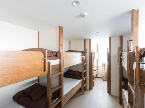a room with a bunch of bunk beds at Osaka Namba Hostel MIYABI in Osaka
