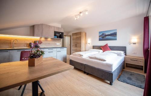 a bedroom with a bed and a kitchen with a table at MOUNTAIN RESIDENCE ALPENHOF - company Hotel Alpenhof KG sas der Gasser Renate in Bressanone