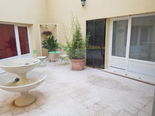 une terrasse avec une grande fenêtre, une table et des chaises dans l'établissement LE PATIO, à Sarrians