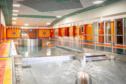 a swimming pool with a water fountain in a building at Hotel Sluníčko in Ostravice