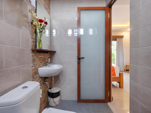 a bathroom with a toilet and a sink at Kubu Belona Canggu in Canggu