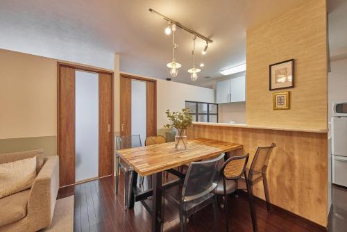 a kitchen and dining room with a wooden table and chairs at SuiteRoom Hana in Osaka