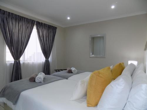 een slaapkamer met twee bedden en een raam bij 2-Bedroom Apartment within 1km of The Point Beach in Mosselbaai