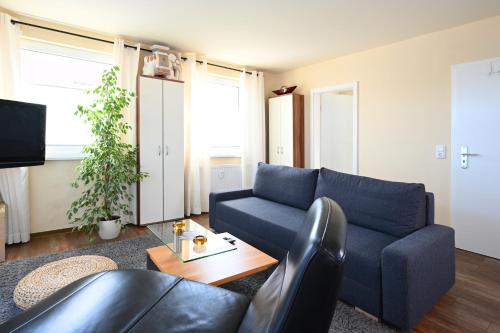 a living room with a blue couch and a table at Hafenresidenz in Malchow