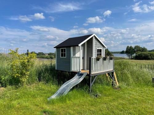 a tiny house with a slide in a field at Dwa Żurawie - Głuszyn in Głuszyn