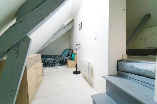 Habitación en el ático con escalera y sofá en Coeur de Rouen en Ruan