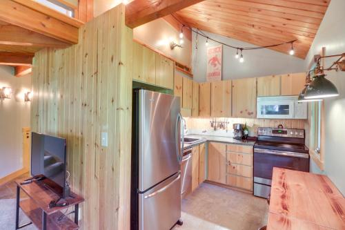 a kitchen with wooden walls and a stainless steel refrigerator at Cozy Resort Condo about 2 Mi to Whitefish Mtn Resort! in Whitefish