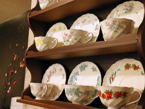 a group of cups and saucers on shelves at Gasthof Schi Heil in Nozawa Onsen