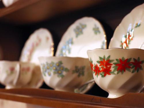 a group of china dishes and spoons on a shelf at Gasthof Schi Heil in Nozawa Onsen