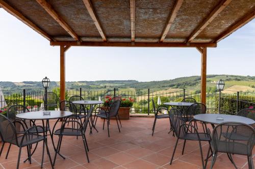 a patio with tables and chairs with a view at Suite Fattore in San Gimignano