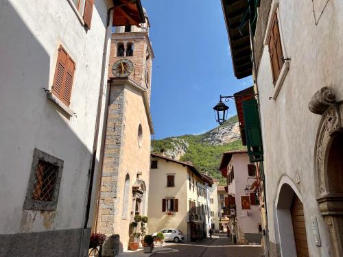 a building with a clock tower on a street at Appartamenti Le Tre Rose in Nago-Torbole