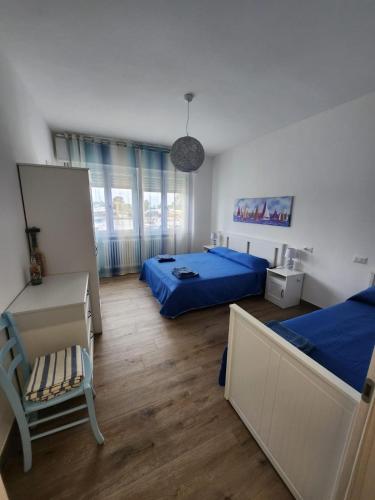 a bedroom with two beds and a chair in it at B&B Nonna Maria in Porto Garibaldi