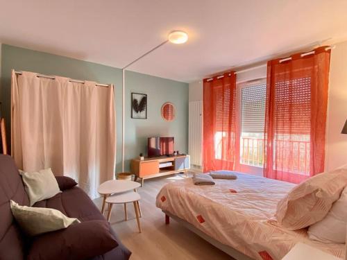 een slaapkamer met een bed en een bank bij T2 cosy proche hôpital + parking gratuit sur place in Auxerre