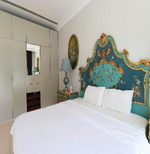 une chambre avec un grand lit blanc avec une tête de lit bleue dans l'établissement Carona amour`, à Cannes