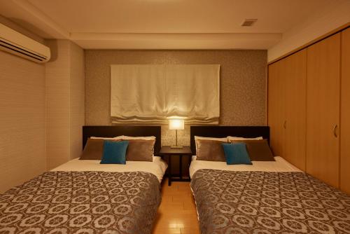 a hotel room with two beds and a window at SuiteRoom Hana in Osaka