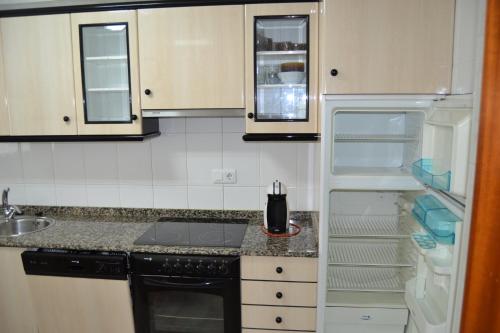 a kitchen with an open refrigerator and a sink at Inmoinsuas Plaza de Galicia 32 in Sarria