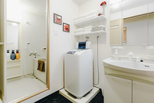 a white bathroom with a sink and a refrigerator at SuiteRoom Hana in Osaka