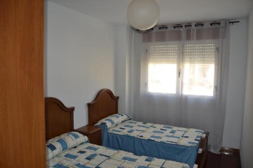 two twin beds in a room with a window at Inmoinsuas Plaza de Galicia 32 in Sarria