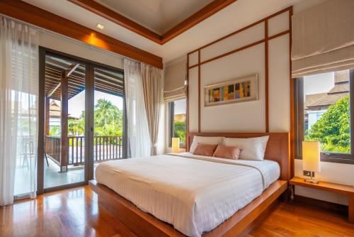 a bedroom with a large bed and a balcony at Villa Autjima krabi /3BRD in Ban Khlong Haeng