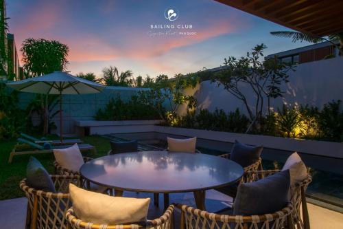 a table and chairs on a patio with a sunset at Sailing Club Signature Resort Phu Quoc in Phu Quoc
