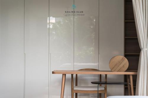 a table and chairs in a room with a glass wall at Sailing Club Signature Resort Phu Quoc in Phu Quoc