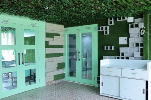 a bathroom with green walls and a glass shower stall at Hotel 7 Heaven in Dehradun