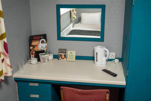 Pokój z biurkiem z lustrem i łóżkiem w obiekcie The Longship w mieście Hebburn