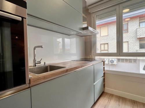 a kitchen with a sink and a window at Acogedor apartamento en Somo in Somo