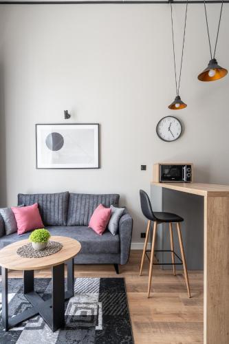 a living room with a couch and a table at RentPlanet - Apartamenty Zarembowicza in Wrocław