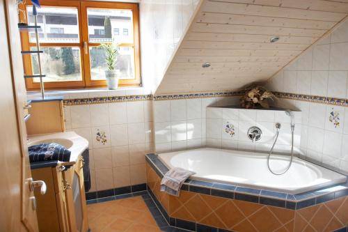リムバッハにあるPension / Ferienwohnungen Ludwigの屋根裏のバスルーム(大型バスタブ付)