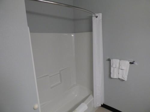 a bathroom with a shower with a white tub at Republic Hotel in Big Lake