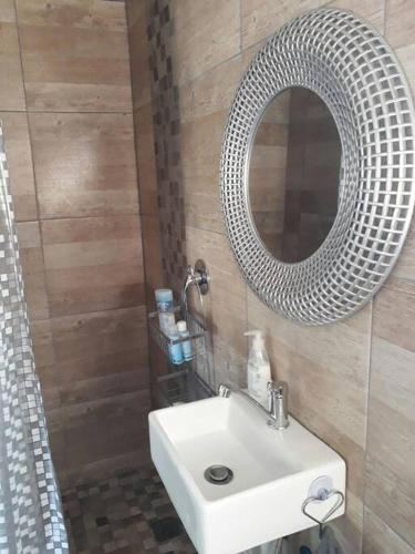 a bathroom with a white sink and a mirror at de Klerens Gems : Emerald Self Catering Unit in Clarens