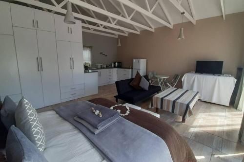 a living room with a large bed and a kitchen at de Klerens Gems : Emerald Self Catering Unit in Clarens
