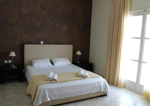 a bedroom with a bed with two towels on it at Diavlos Studios in Agiokampos
