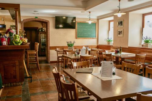 ein Restaurant mit Tischen, Stühlen und einer Tafel in der Unterkunft Guesthouse Turšič in Vrhnika