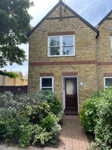 a brick house with a brown door at Courtyard House, with parking and patio garden in Whitstable