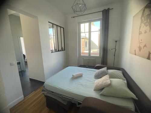 une chambre avec un lit avec des oreillers dessus dans l'établissement Studio Cosy 2 adultes, à Reims