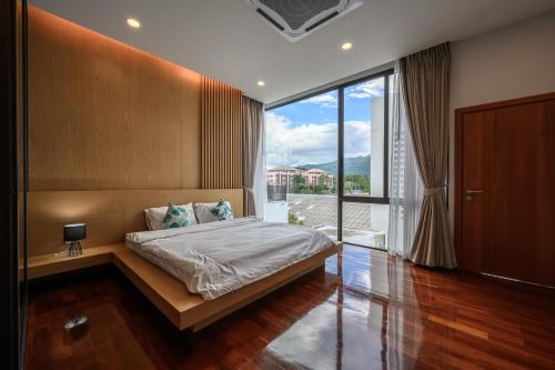 - une chambre avec un lit et une grande fenêtre dans l'établissement Poolvilla Near Nimmanheim - KING BED 3BR, à Chiang Mai