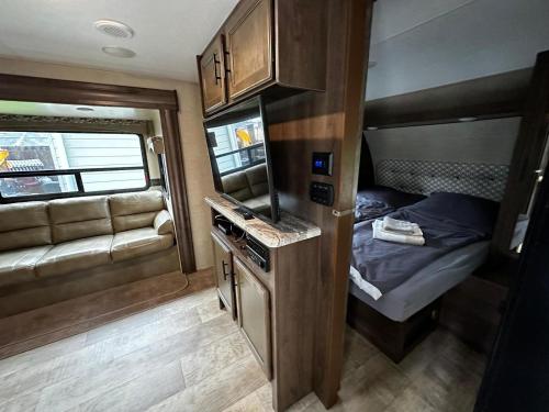 Ein Wohnwagen mit einer Küche und einem Bett darin in der Unterkunft American Camping im US-Wohnwagen in Brandenburg an der Havel