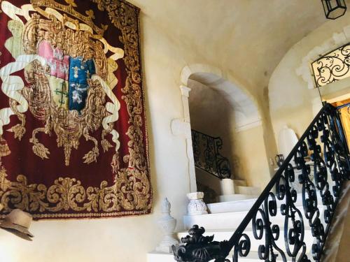 a staircase with a tapestry hanging on a wall at Prieuré du 17è dans l'Ardèche méridionale in Vagnas