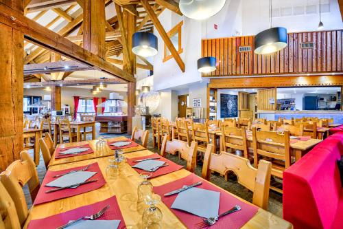comedor con mesas y sillas de madera en Village Club Les Tavaillons, en Les Carroz d'Araches
