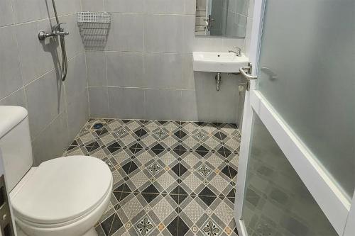 a bathroom with a toilet and a sink at Urbanview Hotel Mutiara Persada Syariah Majalengka by RedDoorz 