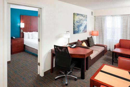 a hotel room with a desk and a bed at Residence Inn by Marriott Dothan in Dothan