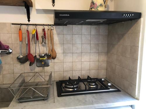 a stove top oven in a kitchen with utensils at TrentapassidalMare Quinto al mare in Genova