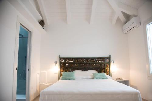 um quarto branco com uma cama branca com almofadas azuis em Bed & Breakfast A Mare em Fano