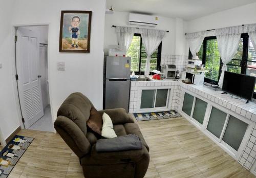 a living room with a couch and a kitchen at Khod’s House in Chiang Mai