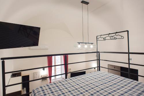 - une chambre avec un lit et une télévision murale dans l'établissement Madaleni Home Plebiscito, à Naples