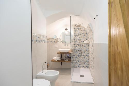 La salle de bains est pourvue de toilettes et d'une douche en verre. dans l'établissement Madaleni Home Plebiscito, à Naples